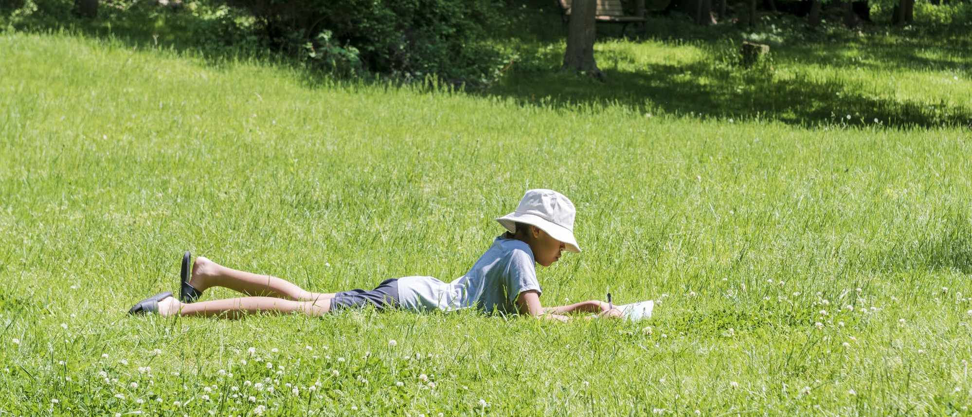 A Wayfinders participant writing outdoors
