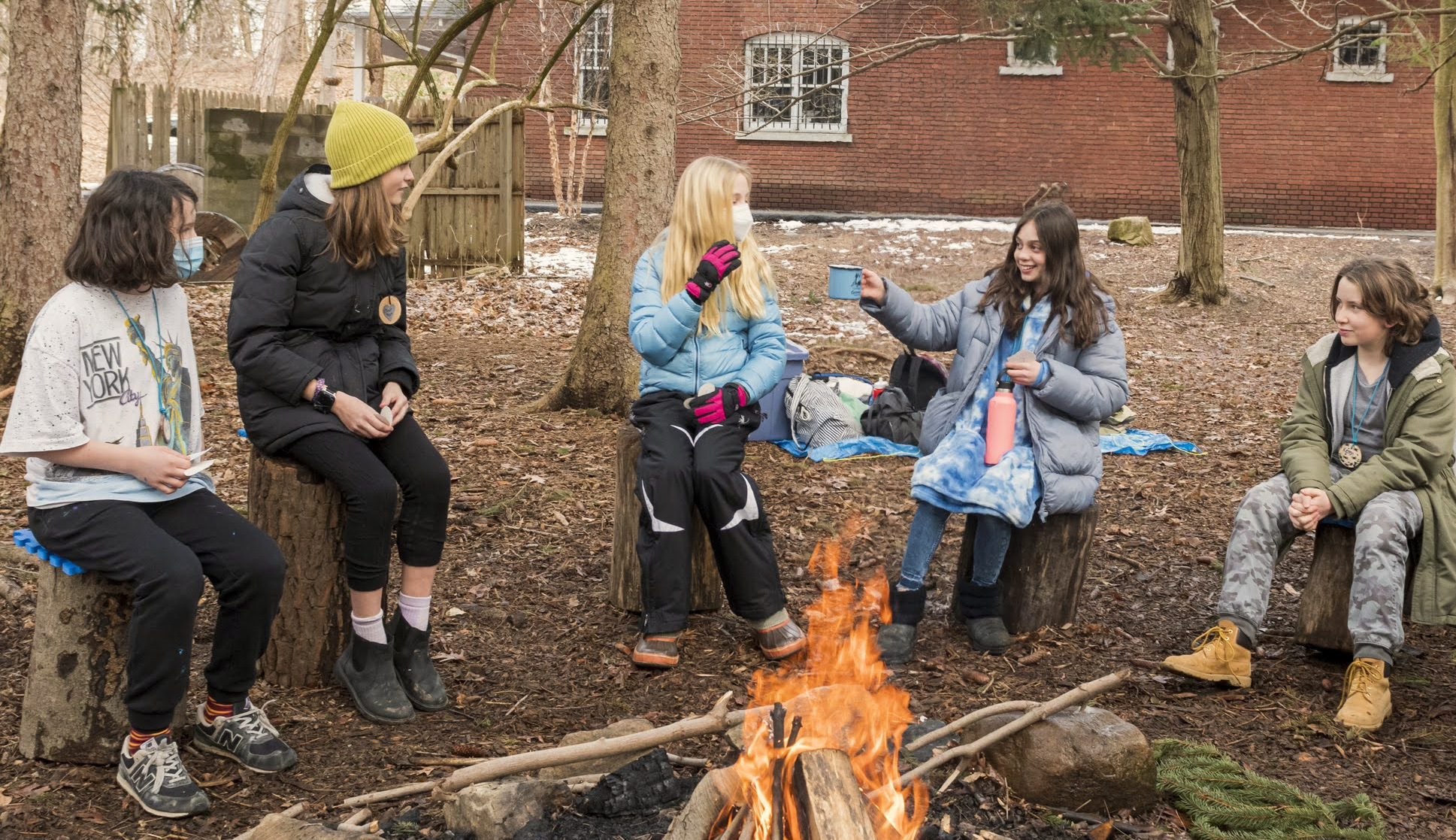 Wayfinders participants gathered around a fire outdoors