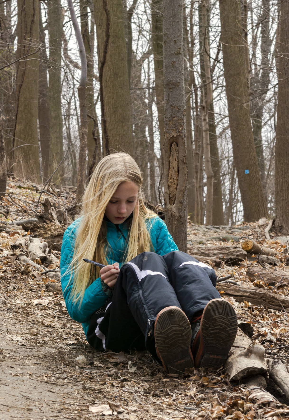 A Wayfinders participant writing and reflecting outdoors