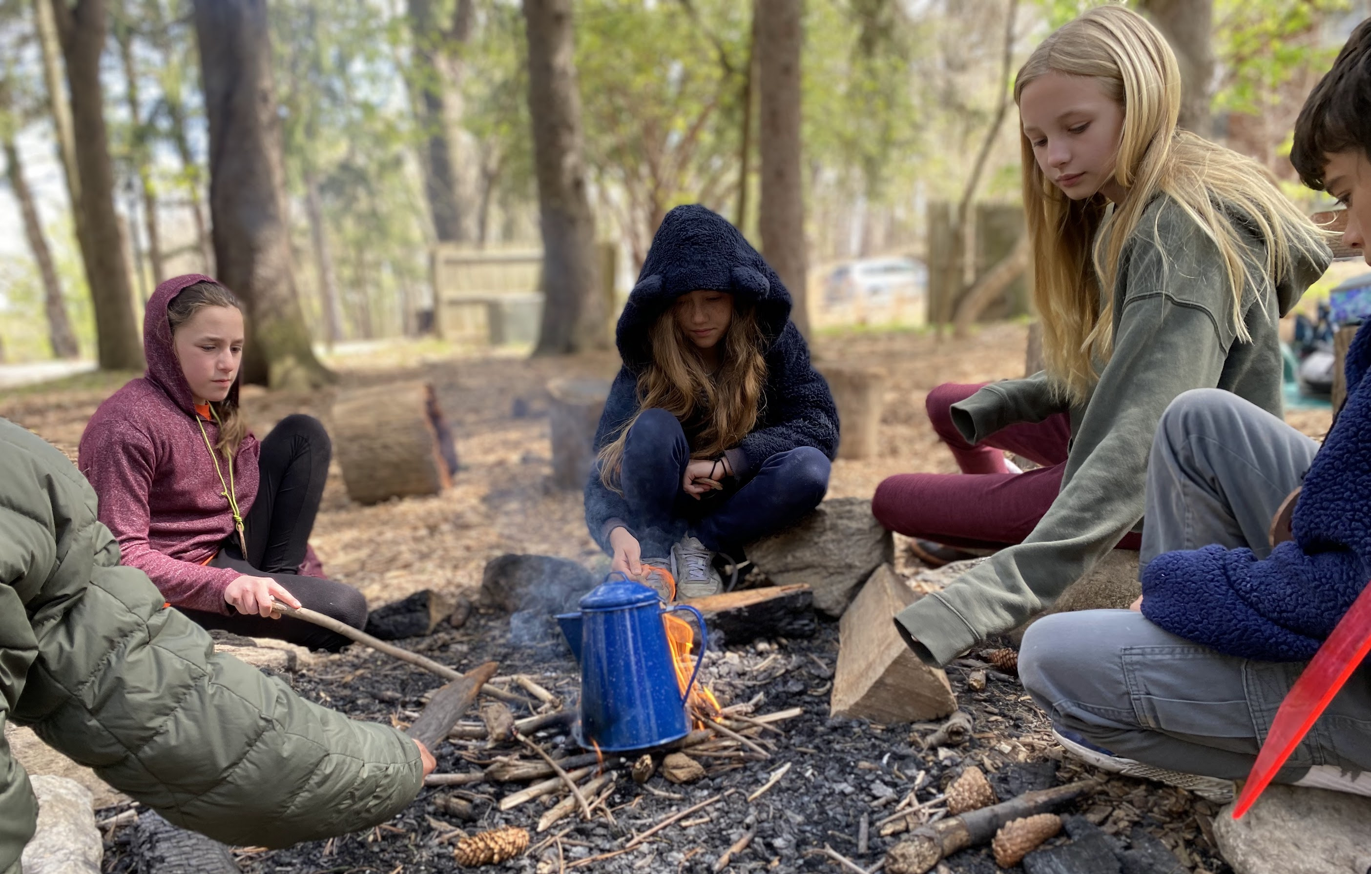 Tea prepared beside a fire outdoors